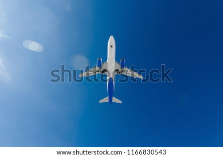 medium size white passenger airplane on a clear sky background. bottom view a few seconds before landing. composition photography. flying overhead to destination airport travel and journey concept.
