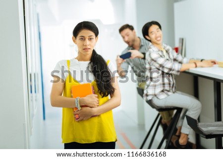 Bullying. Nervous young girl being new at the university and suffering from men taking photos of her while being at the university