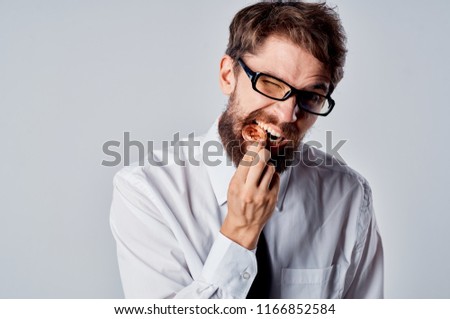  a man in glasses bites a coin in his hand                               Royalty-Free Stock Photo #1166852584