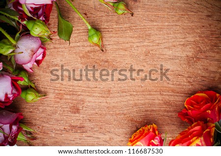 Beautiful bouquet of multicolored roses on a wooden board, close-up, ready background