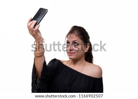 A young Indian female model clicking her selfie with her phone or mobile