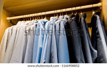 Hangers with male clothes in wardrobe closet