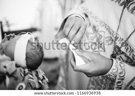 Church. To a little girl and a cross at the ceremony of baptism.Baptizing a child