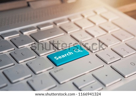 A keyboard with a blue button - Search. Color button on the gray silver keyboard of modern ultrabook. caption on the button