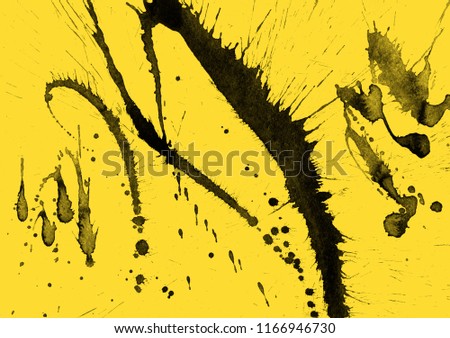 Isolated artistic black watercolor and ink paint splatter textures and decorative elements on yellow paper background.