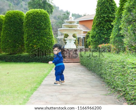 Thai boy in the pilot custome on the grass