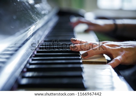 Closeup of antique piano keys and wood grain. musician hands playing piano on piano keyboard.low key tone image. abstract musical background.