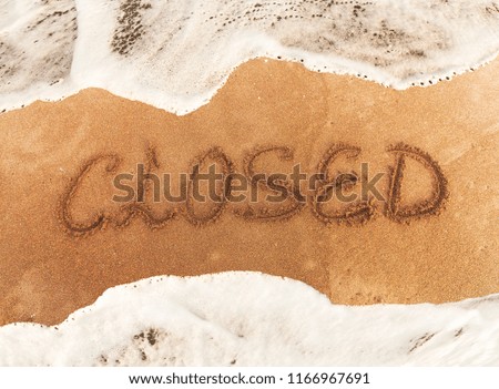 inscription CLOSE on the yellow  sand