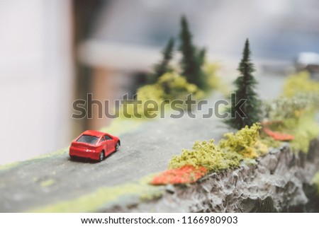 Red Car toy driving on the country road