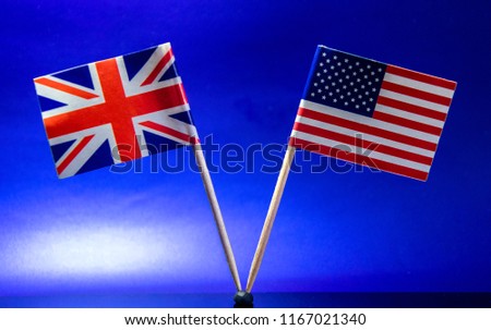 The American and British flags stand side by side against a sky blue background.