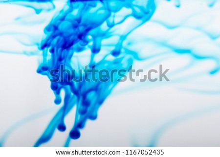 Drops of blue ink in water, can be used as a smoke texture, partially white background