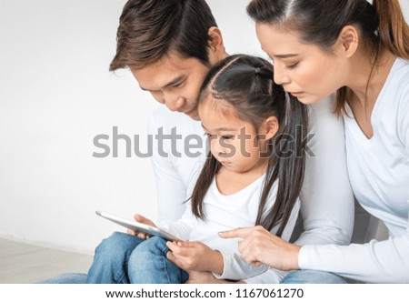 Happy Asian family using laptop for studying online and enjoying watching kid's cartoon movie relaxing at home for technology lifestyle concept