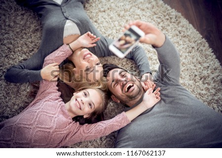 Top view of happy family are smiling to the camera,take selfie and lying on the floor.Family, children and home concept.