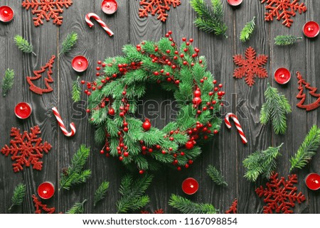 Christmas composition with wreath and festive decorations on wooden background