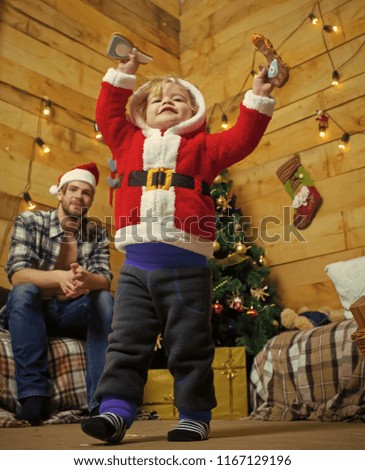 Christmas happy child and father with gift on wooden background. Xmas party celebration, fathers day. New year small boy son and man. Winter holiday. Santa claus kid and bearded man at Christmas tree.