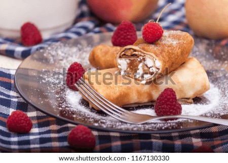 Homemade pancakes with cream cheese, raisins and raspberry on a plate. Maslenitsa.