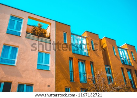 real estate picture of modern townhouses with pink and orange facade