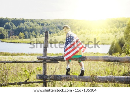 Man with the flag of the United States of America, against the sky with sunset. Independence Day, patriot, military.
