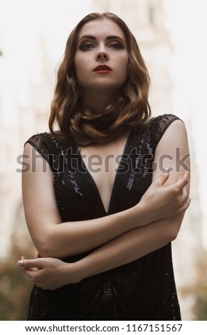 Portrait goth girl outdoor. Wearing black dress, white skin red lips and blonde long hair, standson street .Beautiful witch outdoor. Halloween Vampire beautiful woman portrait