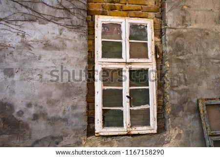 old white window frames with glass backs against a wall