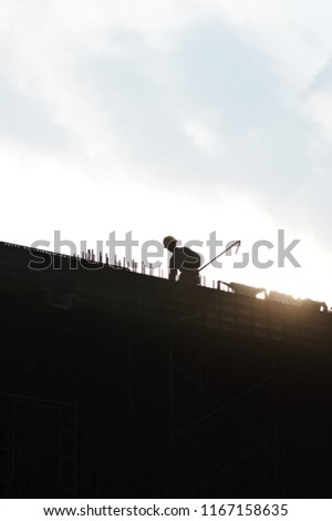 Construction workers on top of building during sunset