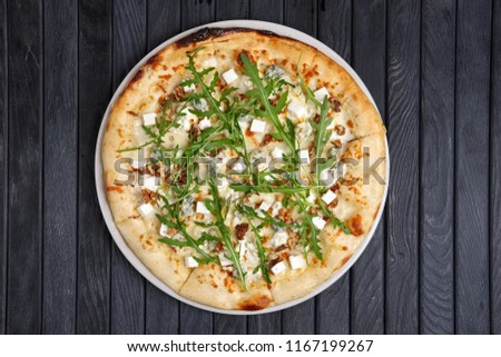 Top view of pizza with different kind of cheese with arugula
