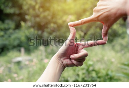 Hands of person making frame distance or symbol in nature.