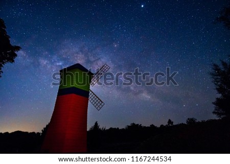Landscape of milky way galaxy with wind turbine, Night sky with stars and silhouette of wind turbine and tree