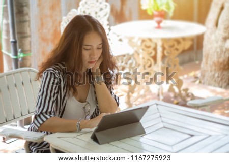 Close up of young female freelance designer works on tablet seriously. Female student studying via tablet.