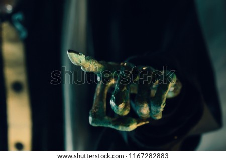 View of hand pointing of witch on dark background. Dark tone. Shallow depth of field.
