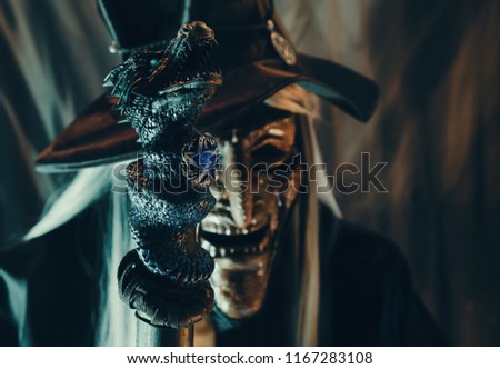 View of dragon wand and witch on dark background. Dark tone. Shallow depth of field.