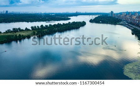 KYIV-22 JULY,2018: Aerial drone photo of beautiful river Dnipro in Obolon district of Kiev city in Ukraine. Blue sky and reflection on water surface at river Dnieper.Small tourist boats float 