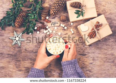 Cocoa, coffee, gift, fir branch, nuts, cones, cozy knitted blanket.  Christmas cookies A woman's hand holds a cup. Winter, New Year, Christmas still life. 