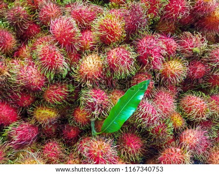 Rambutan ripe sell in the supermarket, Red fruit with hair and leaves.