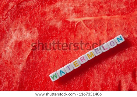 The inscription of the watermelon is made of cubes with letters lying on a watermelon with copyspace