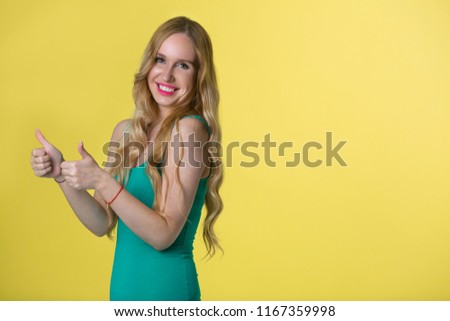 beautiful young girl with her hair on yellow background with gesture of hands
