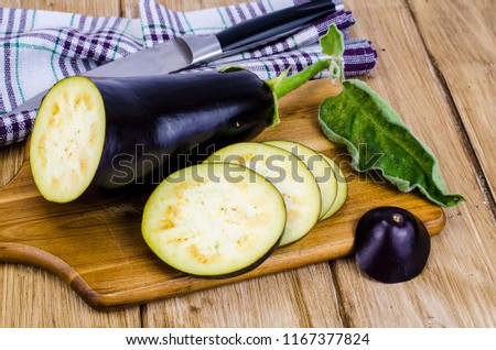 Ripe purple aubergine on wooden background. Studio Photo
