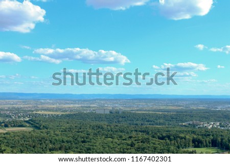 Amazing Landscape view on the beautiful forests, alpine mountains and idyllic fields of South Germany with a blue sky before sunset with clouds