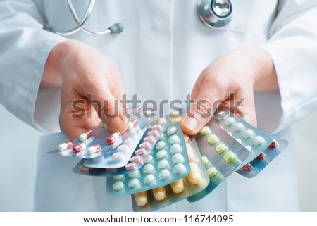Hand of doctors holding many different pills Royalty-Free Stock Photo #116744095