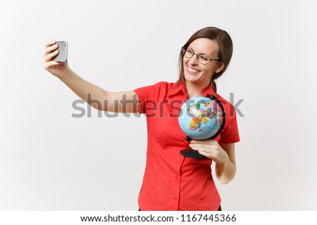 Smiling business teacher woman in red shirt holding mobile phone and doing taking selfie shot with globe isolated on white background. Education teaching in high school university concept. Copy space