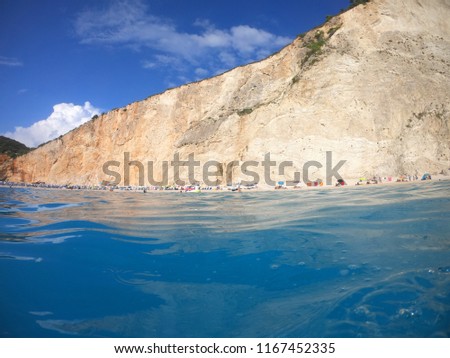 Sea level photo of iconic paradise beach of Porto Katsiki with turquoise clear sea, white rock steep cliffs and beautiful clouds , Leflkada island, Ionian, Greece