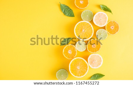 Creative background made of summer tropical fruits with leaves, grapefruit, orange, tangerine, lemon, lime on pastel yellow background. Food concept. Flat lay, top view, copy space Royalty-Free Stock Photo #1167455272