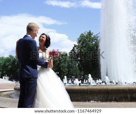beautiful smiling couple standing near the fountain
