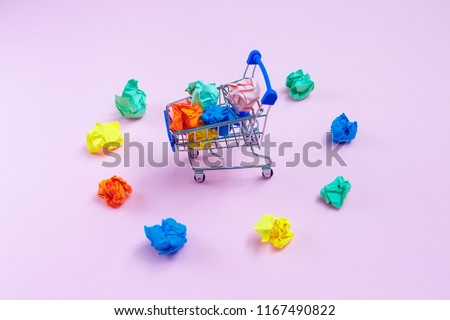 Full basket with crumpled paper balls and scattered colored crumpled balls around the basket on pink background . top view Concept ideas. Flat lay. choice, decision,