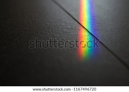 Minimalist composition of small spectrum from glass reflex cross line on floor. Close up macro photo can show how beautiful of rainbow glare spectrum that look science and interesting to learning.
