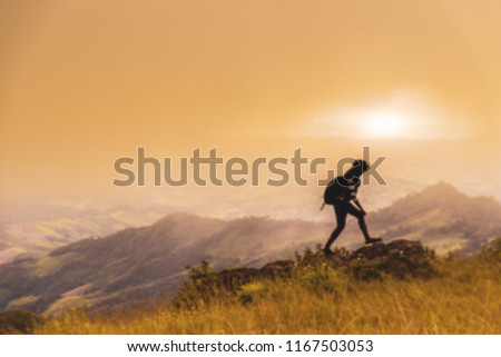 Blured image silhoutte picture of young woman with backpack and trekking in the mountains. Concept healthy and active lifestyle. Girl on nature background