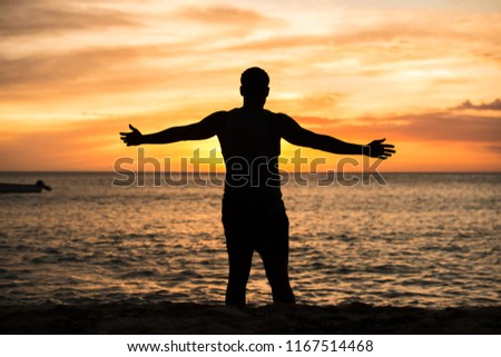 is the silhouette of a man in the sunset beach