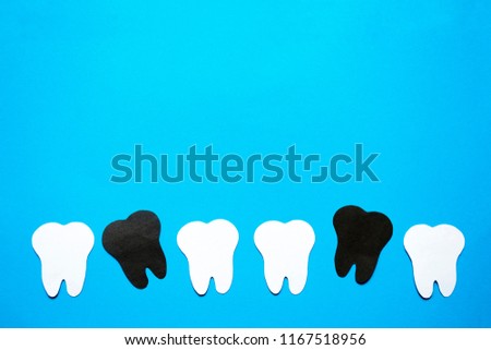 Sick teeth among healthy ones background.