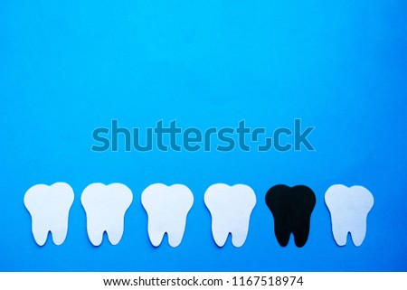 Sick tooth among healthy ones background.