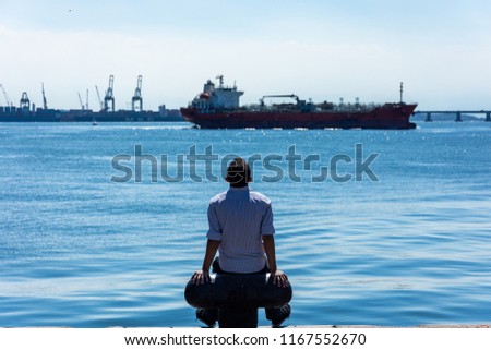 Man sitting and watching the beautiful view of ocean, in a sunny winter day, at Rio de Janeiro.